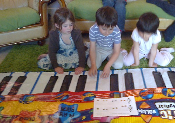 Orchestre sur grand piano : chaque enfant est responsable d'une ou deux notes.